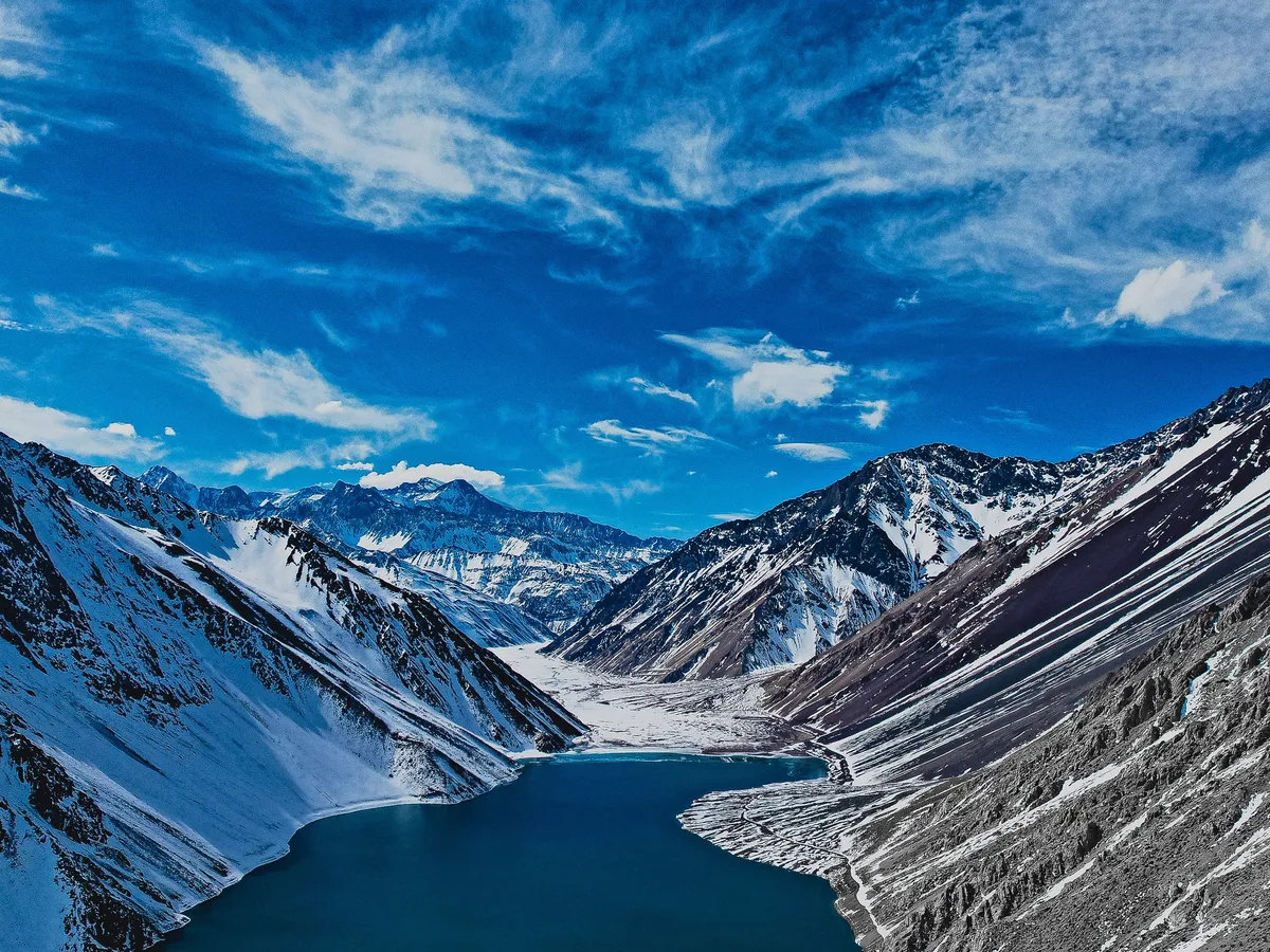 Luftfoto af Embalse El Yeso-reservoiret under sne, omkranset af Andesbjergene over Santiago